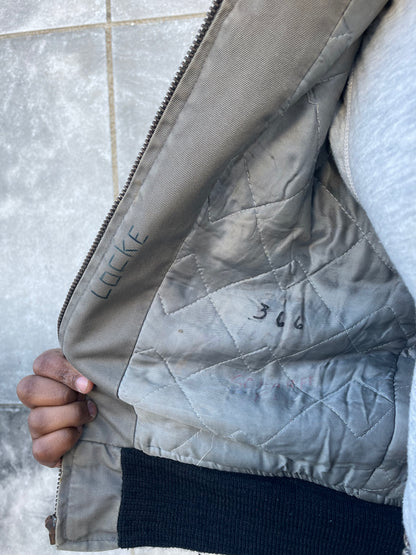 Inside of the jacket showing the quilted lining, knit waistband and handwritten ink marks