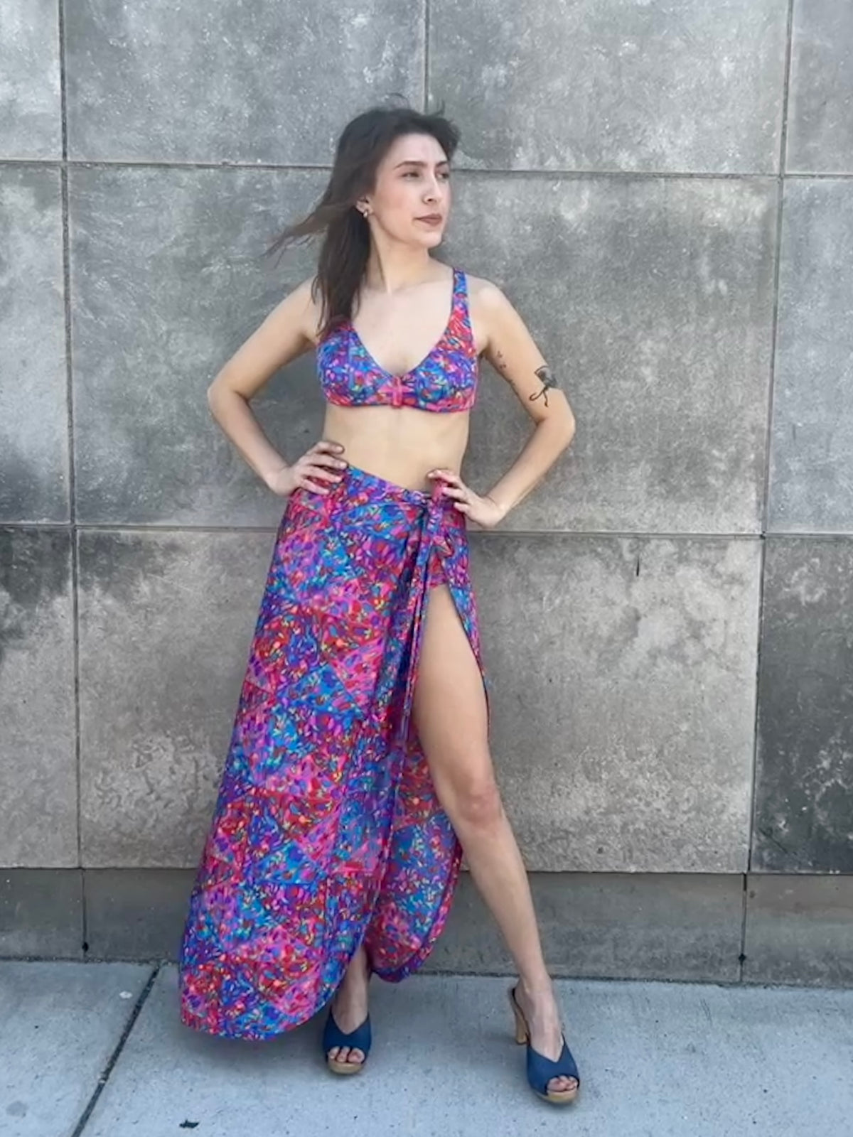 Bikini top and wrap skirt on the model, hands on hips, showing the slit and long hem