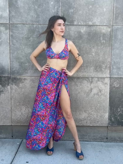 Bikini top and wrap skirt on the model, hands on hips, showing the slit and long hem
