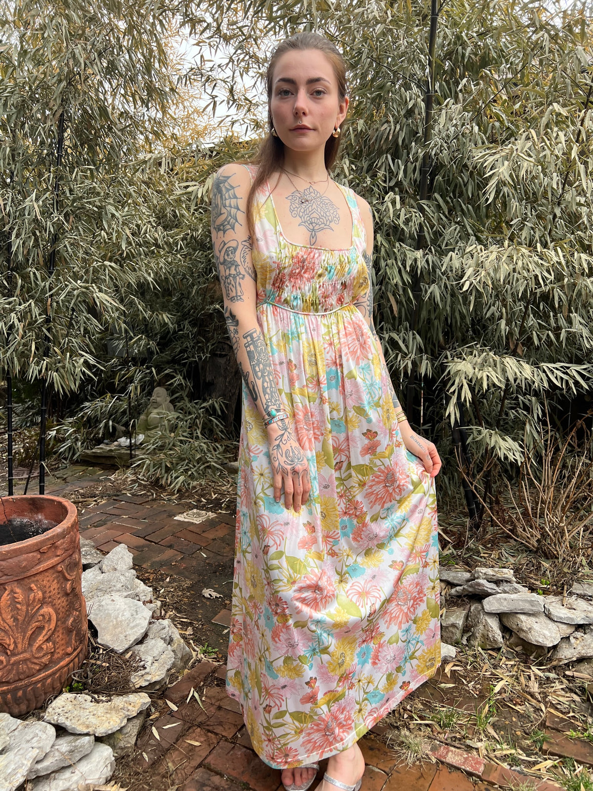 Front view of the sleeveless gown on its own, with ruched bodice and floral skirt, on the model